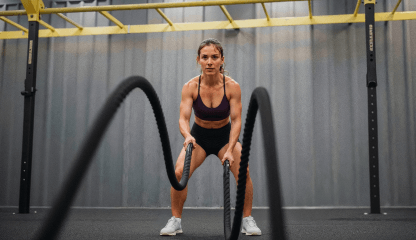 Aluna usando battle ropes na aula de Smart Cross