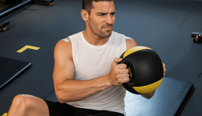 Aluno praticando exercício funcional com medicine ball na Smart Fit