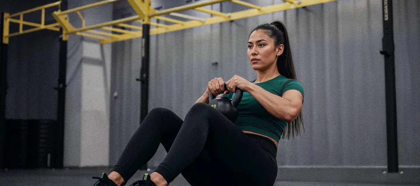 Aluna praticando treinamento funcional com kettlebell na Smart Fit