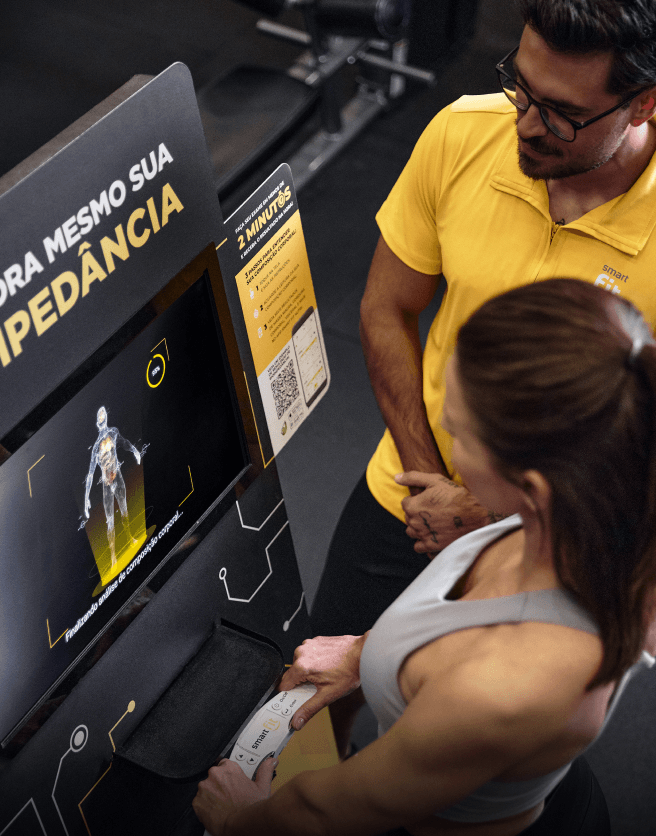 Aluna e Coach analisando resultados na academia Smart Fit
