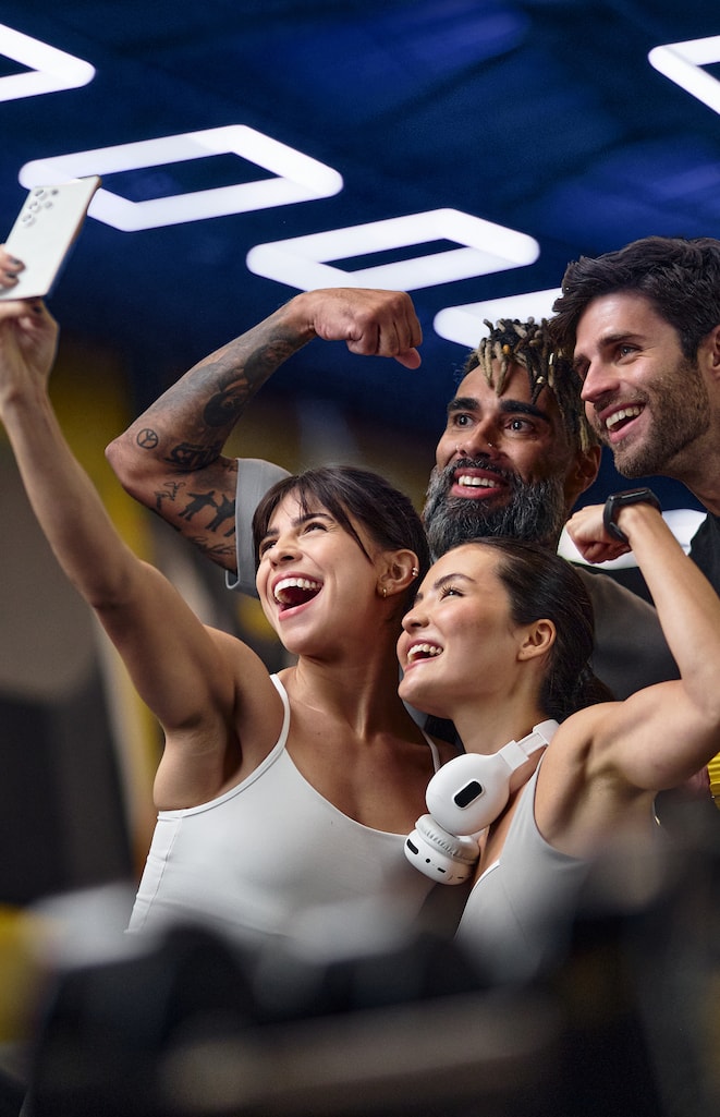 Pessoas treinando e sorrindo juntas em uma unidade Smart Fit