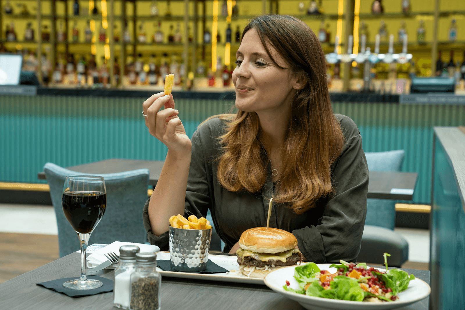 Mulher comendo batata frita em um restaurante