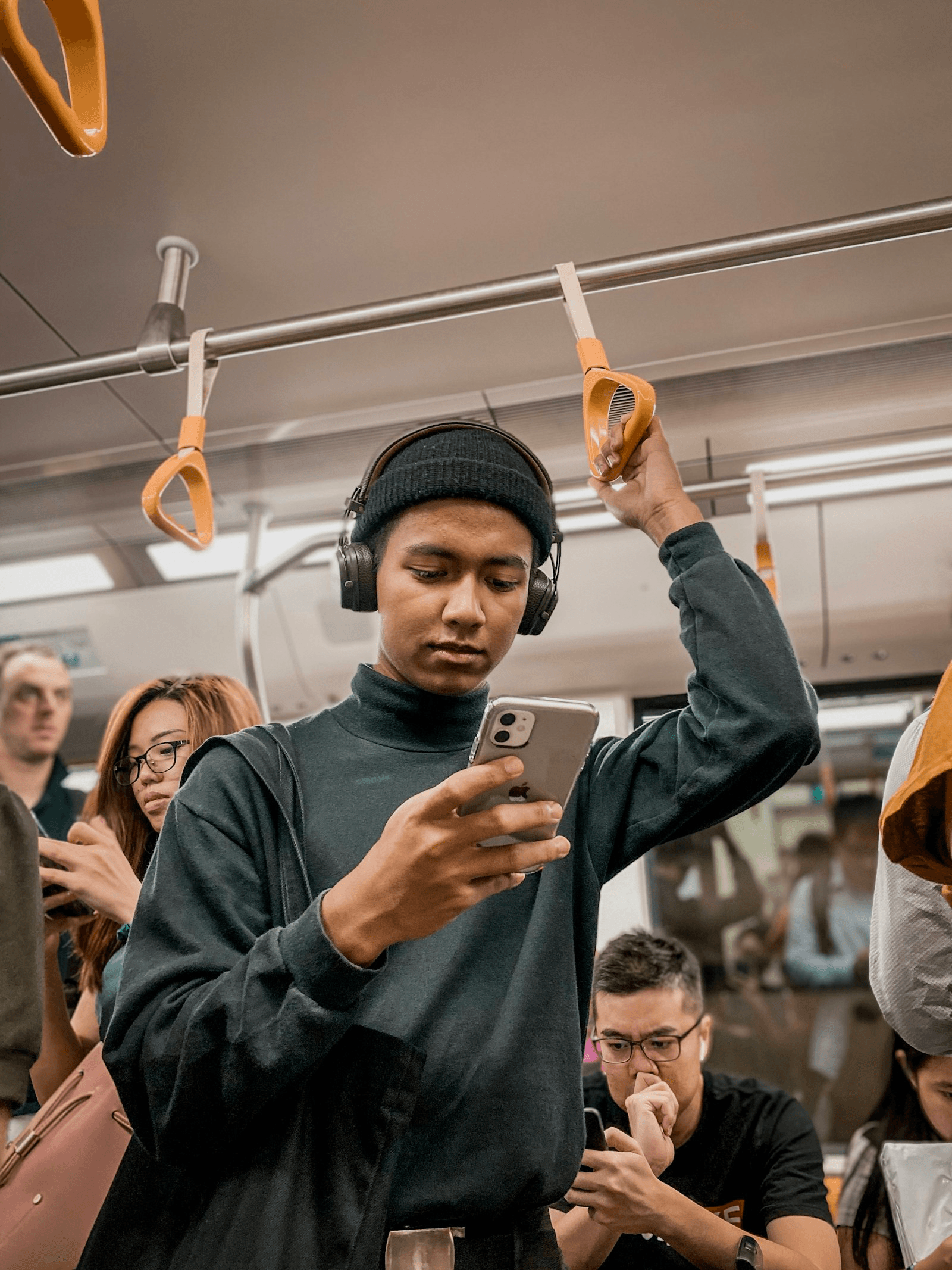Homem usando fones de ouvido e celular no transporte público