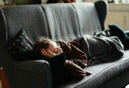 Imagem mostra pessoa deitada no sofá