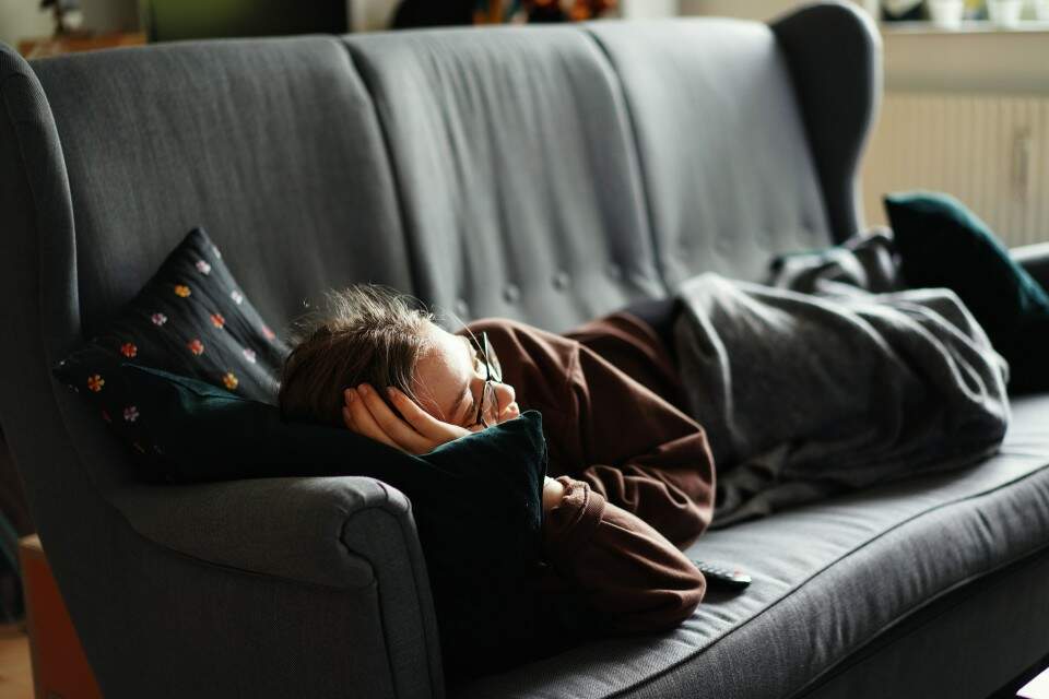 Imagem mostra pessoa deitada no sofá