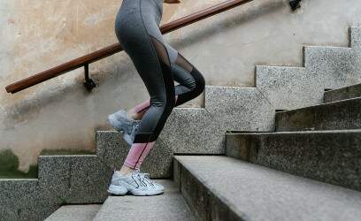 Mulher subindo escadas em roupas de academia