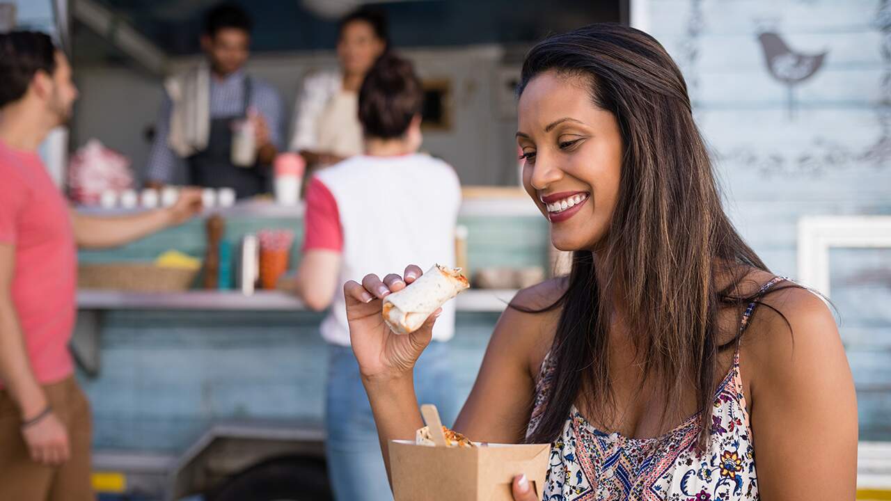 Mulher comendo para ter calorias necessárias para o processo de hipertrofia