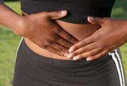 Imagem mostra mãos femininas sobre a barriga, na altura do útero