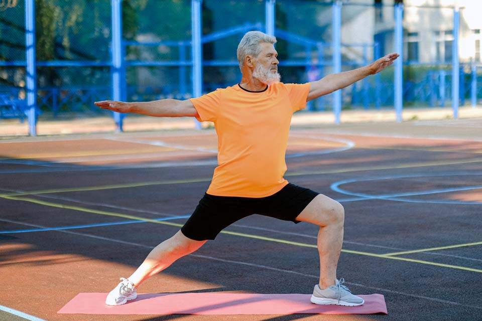 Imagem mostra idoso praticando atividades físicas em uma quadra a céu aberto