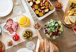 Na imagem, diversos alimentos estão espalhados em uma mesa para simbolizar os nutrientes