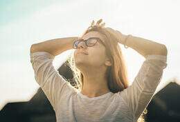 Imagem mostra mulher de óculos tomando sol ao ar livre