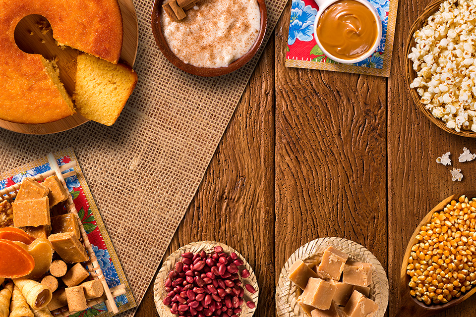 Imagem mostra diversos pratos clássicos de festa junina distribuídos em uma mesa