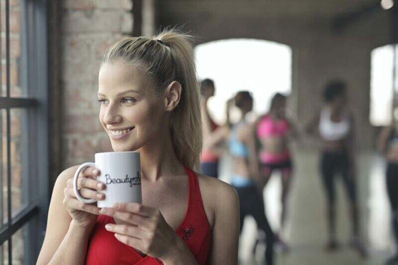 Imagem mostra mulher sorrindo em ambiente de academia