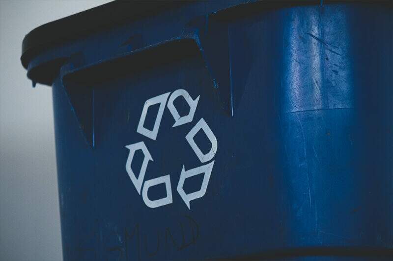Imagem mostra uma lixeira azul com o símbolo da reciclagem