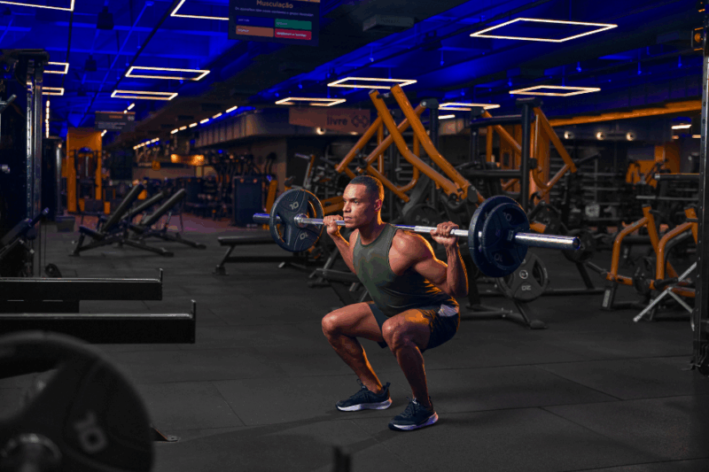Homem fazendo musculação em uma academia smart fit.