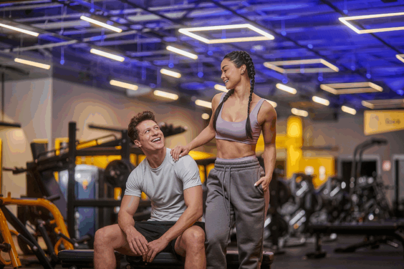 Casal fazendo pose na academia para tirar foto.