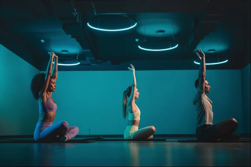 Três pessoas praticando yoga em um estúdio moderno.