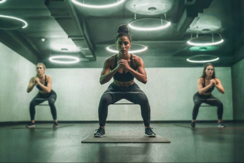 Grupo de mulheres malhando em academia moderna.