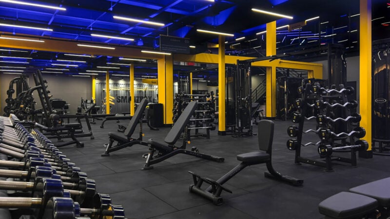 Interior moderno de academia com equipamentos de musculação.