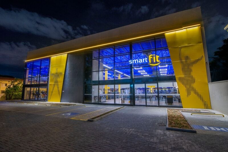 Fachada da academia Smart Fit iluminada à noite